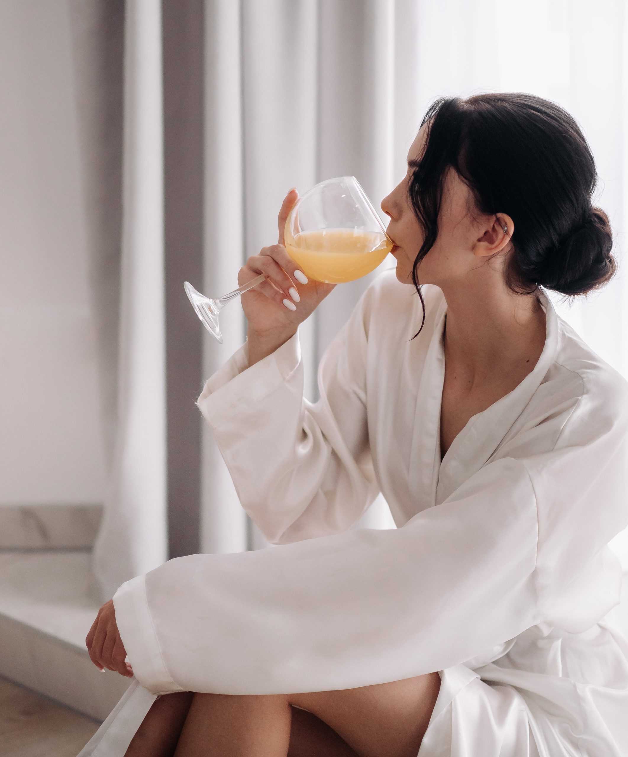 woman in robe drinking juice