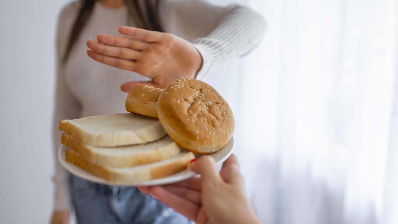 a young woman saying no to bread