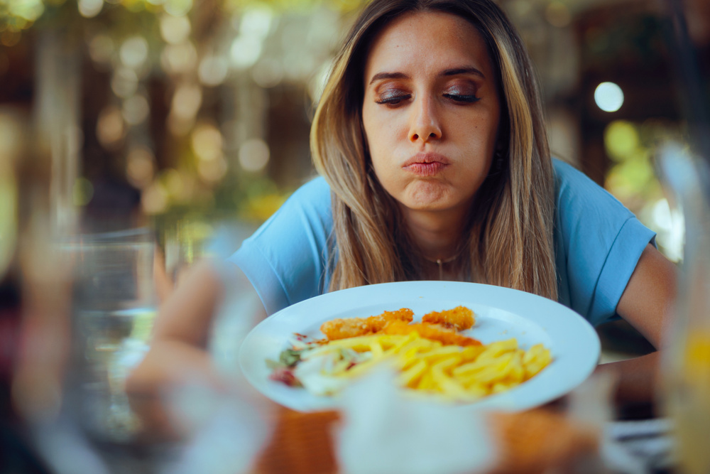 Capricious woman dinning out being dissatisfied with her meal