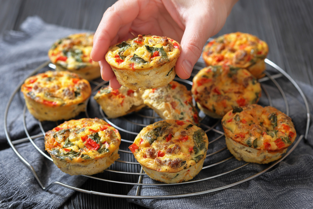 Frittata egg muffins with ground beef, red bell pepper, asparagus and spinach on a round wire rack