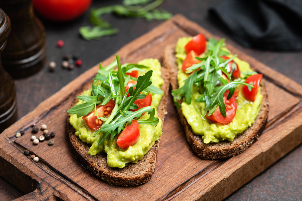 Gluten-free vegetarian toast with mashed avocado and tomatoes